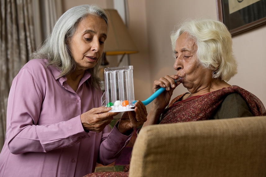 Woman using an incentive spirometer