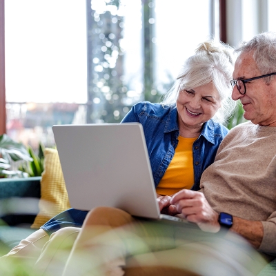 A couple snuggled together looking at a laptop