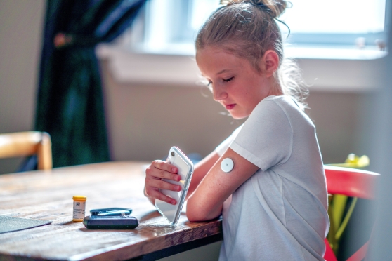 A young girl checks her glucose levels.