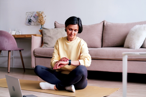 A woman sits on a yoga mat.